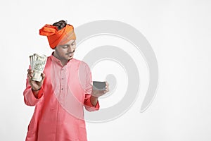 Young Indian farmer posing with currency on white background