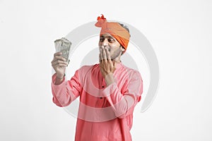 Young Indian farmer posing with currency on white background