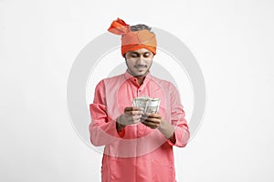 Young Indian farmer posing with currency on white background