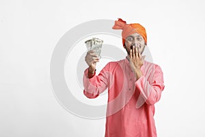 Young Indian farmer posing with currency on white background