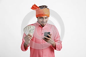 Young indian farmer using smartphone and showing money on white background