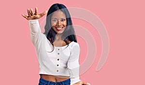 Young indian girl wearing casual clothes looking at the camera smiling with open arms for hug