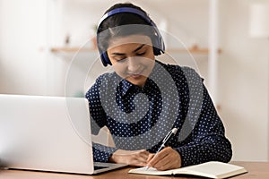 Young indian lady wearing headphones practice in distant learning