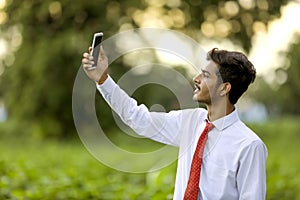 Young indian man clicking selfie with mobile