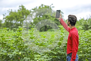 young indian man clicking selfie with mobile