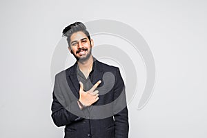 Young indian man pointing at something interesting on a white background