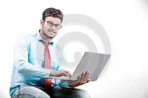 Young Indian man on spectacles and using laptop