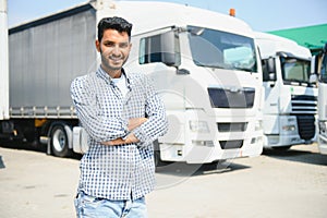 Young indian man standing in front of his truck.