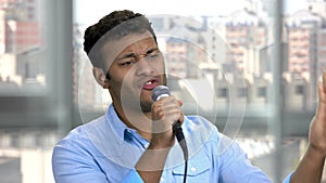 Young indian singer performing with microphone.