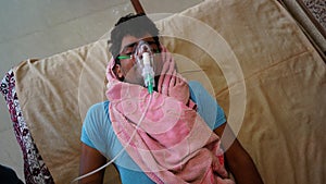 Young Indian taking Emergency Oxygen with Cannula outside of hospital. Severe causes due to Covid in India concept