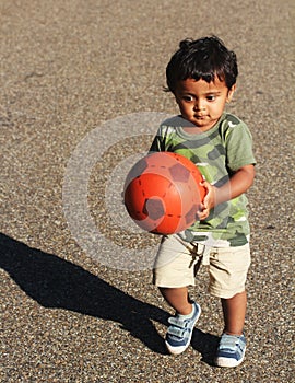 A Young Indian Toddler playing with ball