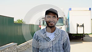 Young Indian truck driver standing by his truck. Concept of road freight transportation