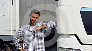 Young Indian truck driver standing by his truck. Concept of road freight transportation