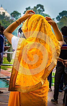 Young Indian woman adjusts her sari scarf on her head