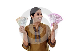 Young Indian woman holding 2000 & 100 currency notes