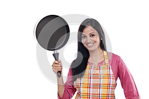 Young Indian woman holding kitchen utensil