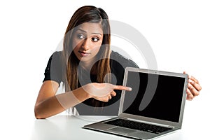 Young Indian woman pointing to laptop.