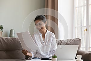 Young Indian woman read paper notification feels happy