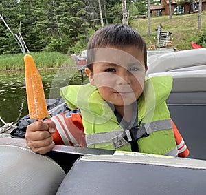 Young Indigenous boy enjoying a popsicle on the lake