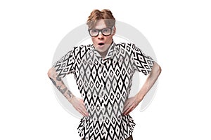 young indignant caucasian man with reddish-golden hair in a short-sleeved black-and-white summer shirt