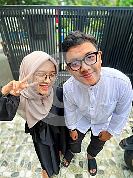 Young Indonesian family, happy brothers and sisters celebrating Eid al-Fitr at home