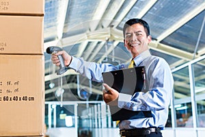 Young Indonesian Man in warehouse with Scanner