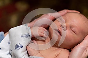 Young infant smiles and plays on his playmat