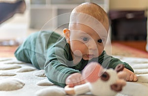 Young infant smiles and plays on his playmat