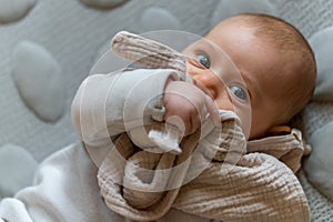 Young infant smiles and plays on his playmat