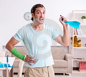 Young injured man cleaning the house