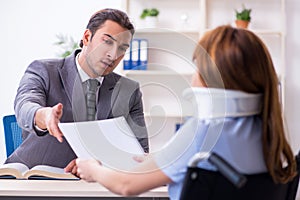 Young injured woman and male lawyer in the courtroom