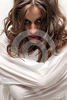 Young insane woman with straitjacket looking