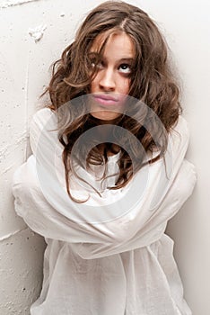 Young insane woman with straitjacket looking up