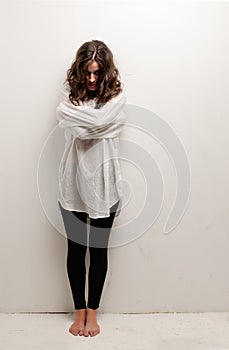 Young insane woman with straitjacket standing