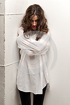 Young insane woman with straitjacket standing