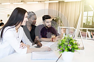 Young international professional team discussing business plan in the office