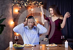 Young Interracial Couple Arguing During Dinner Date In Restaurant photo