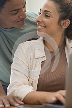 Young interracial couple working together with laptop. People lifestyle at home together using internet connection-Â Man and