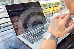 Young investor watching the change of stock market on laptop