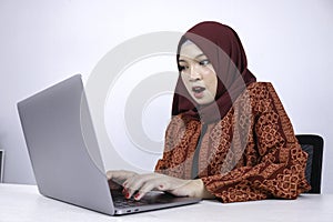 Young Islam woman is shock when holding and working on laptop computer isolated white background