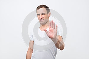Young italian man shows stop timeout or refusal sign with hand