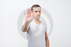 Young italian man shows stop timeout or refusal sign with hand photo