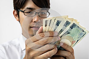 Young Japanese businessman counting money.