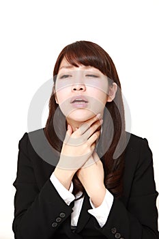 Young Japanese businesswoman having throat pain