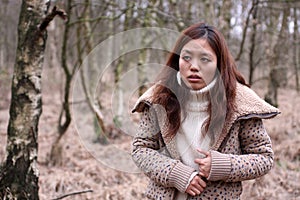 Young Japanese girl feeling at unease in a forest