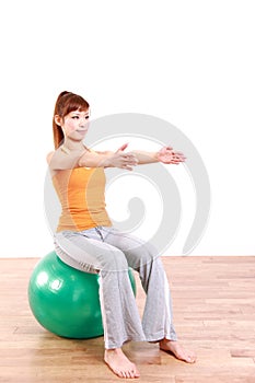 Young Japanese woman doing exercise with fitness ball