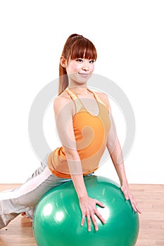 Young Japanese woman doing exercise with fitness ball