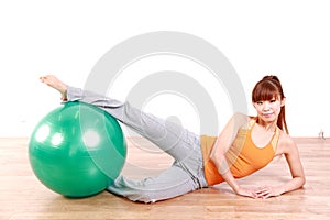 Young Japanese woman doing exercise with fitness ball