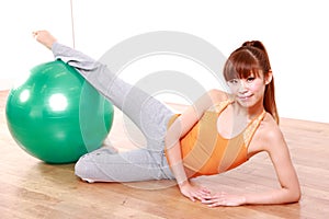 Young Japanese woman doing exercise with fitness ball