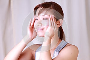 Young Japanese woman doing a self face massageã€€